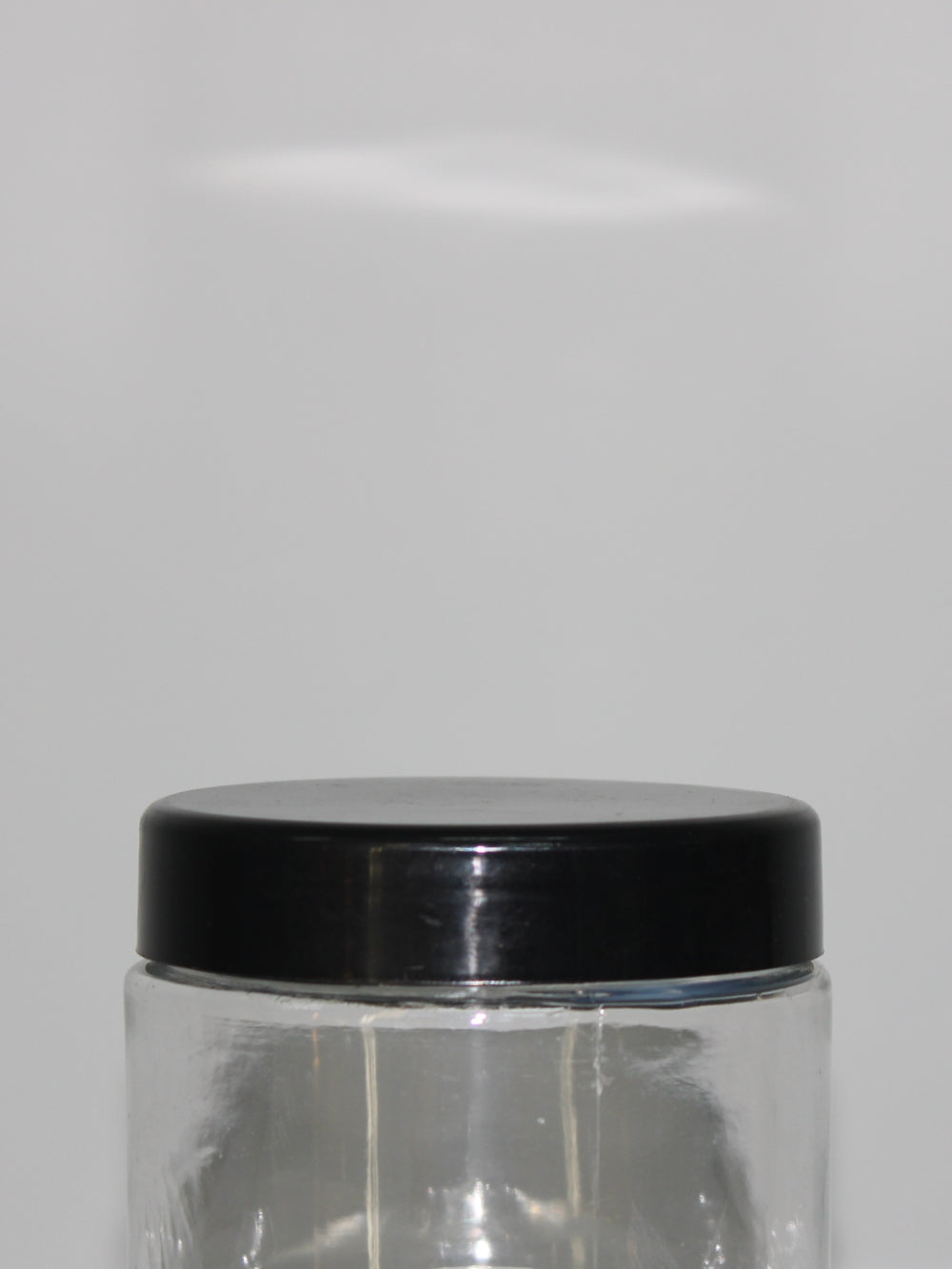 A clear Crystal PET plastic cosmetic jar with a black lid, intended for packaging cosmetic products.